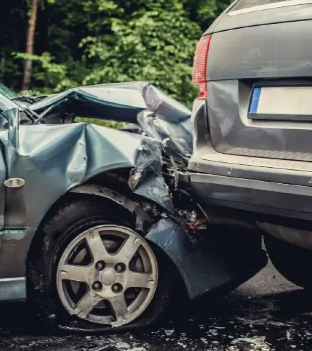 Accidente de tráfico entre dos vehículos Choque de un coche compacto contra la parte trasera de un SUV en una carretera.